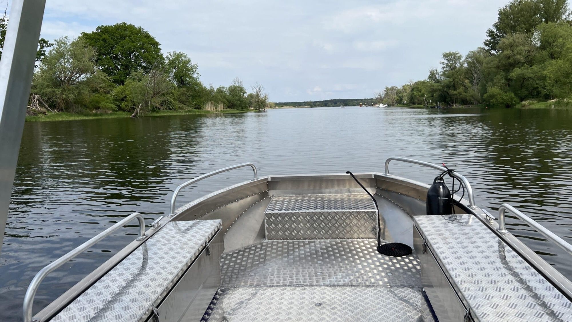 Blick vom Bug eines Aluminiumbootes über die ruhige Havel mit bewaldeten Ufern bei Havelberg